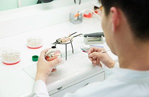 A dental technician working on partial dentures