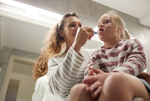  mom brushing teeth for her child with special needs