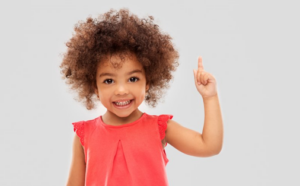 Little girl holding up her finger like she has the answer